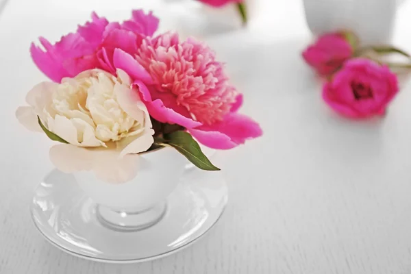 Bouquet de belles fleurs dans une tasse sur une table — Photo