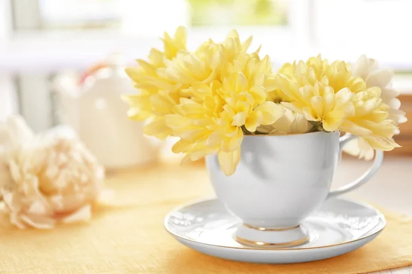 ベージュのナプキンの上にカップの美しい花の花束 — ストック写真