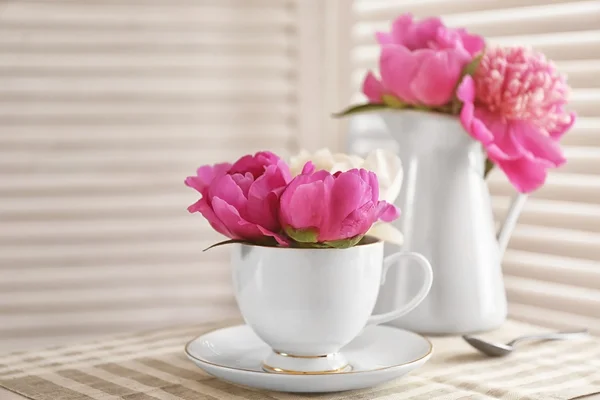 Boeket van mooie bloemen in een kopje op een tafel — Stockfoto