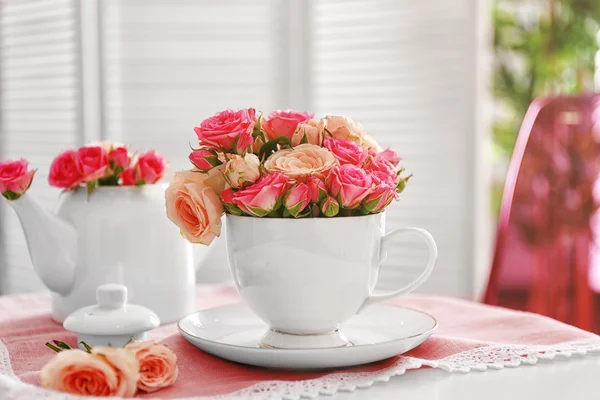 Pink roses in cup on napkin — Stock Photo, Image