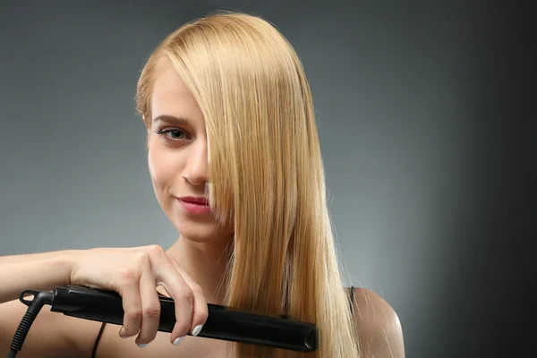 Дівчина Модель Випрямлення Волосся Сірому Фоні — стокове фото
