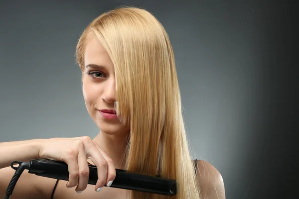 Moda Modelo Menina Endireitando Seu Cabelo Fundo Cinza — Fotografia de Stock