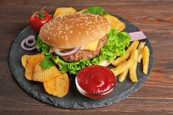 Hamburguesa con papas fritas en un plato de pizarra —  Fotos de Stock