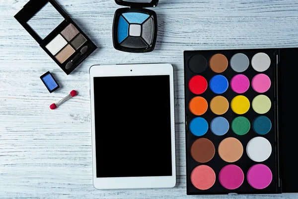 Decoratieve cosmetica en tablet op houten achtergrond — Stockfoto