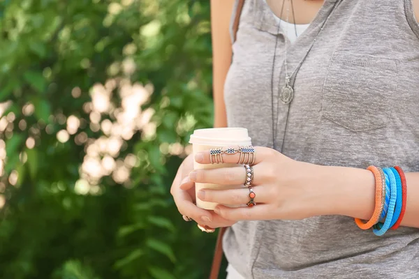 Закрытие женских рук с красивыми бижутериями, держащими чашку кофе — стоковое фото