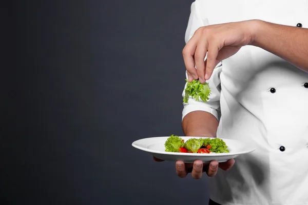 Koch kocht mit Teller mit frischem Salat — Stockfoto