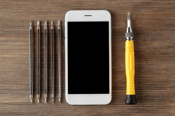 Mobile phone, screwdriver and exchangeable bits — Stock Photo, Image