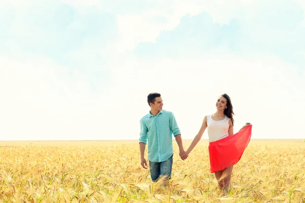 Junges Paar hält Händchen auf schönem Feld — Stockfoto