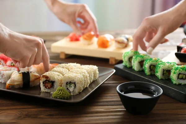 Manos tomando sushi delicioso — Foto de Stock