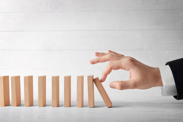 Mano spingendo domino — Foto Stock