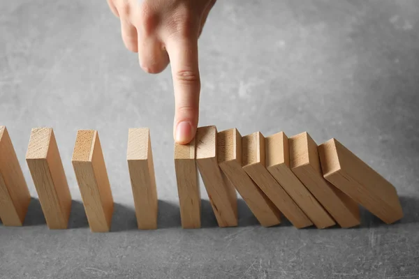 Hand stopping domino effect — Stock Photo, Image