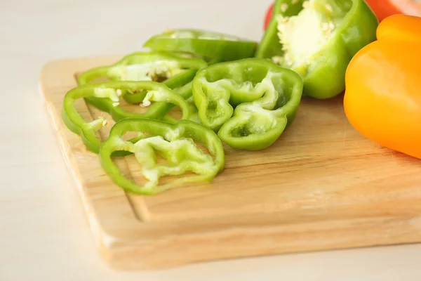 Pepper slices on wooden cutting board — Stock Photo, Image
