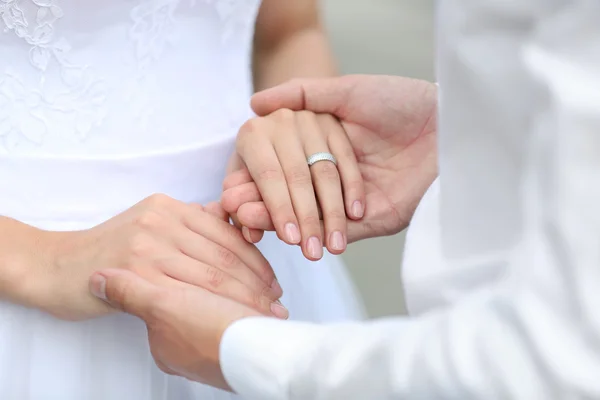 Жених и невеста держатся за руки на открытом воздухе — стоковое фото