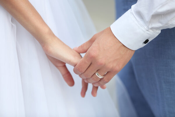 Bride and groom holding hands together outdoor