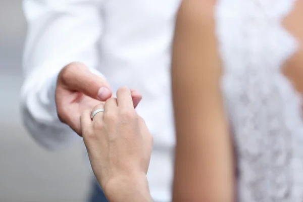 Bruden och brudgummen håller händerna ihop utomhus — Stockfoto