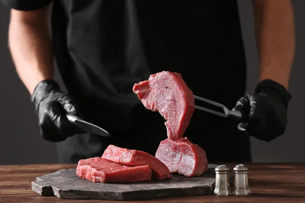 Мясник режет свинину — стоковое фото