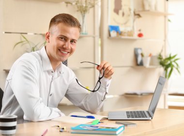 Genç işadamı ofiste çalışıyor.