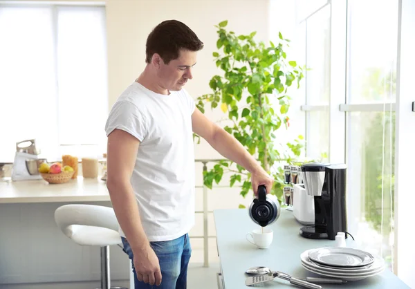 Schöner Mann, der morgens Kaffee in der Küche kocht — Stockfoto