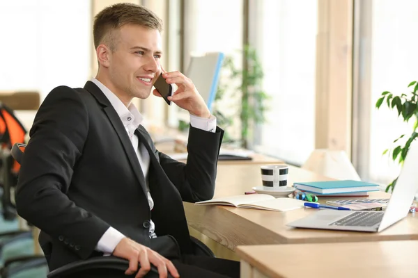 Молодой Человек Разговаривает Мобильному Телефону Работает Ноутбуке Офисе — стоковое фото