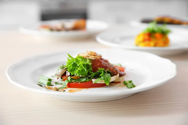 Тарелки с вкусными блюдами на кухонном столе, крупный план — стоковое фото