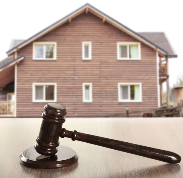 Gavel on wooden house background — Stock Photo, Image