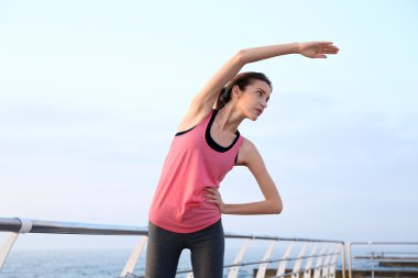 Genç kadın iskelede egzersizleri yapıyor