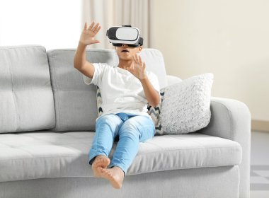 çocuk sanal gerçeklik gözlüğü takıyor.