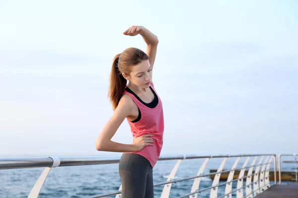 Mujer joven haciendo ejercicios en el muelle —  Fotos de Stock