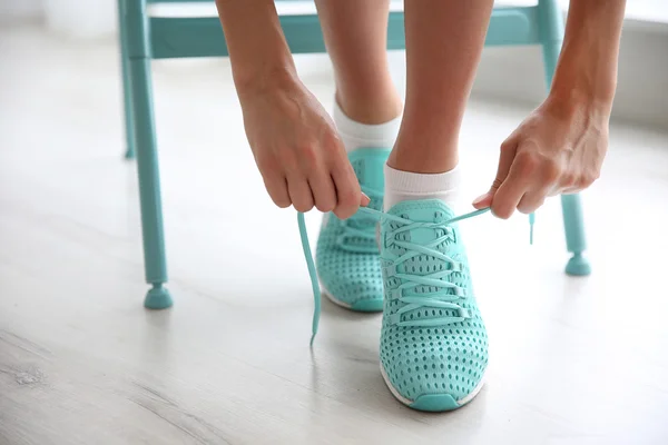 Donna che si lega le scarpe da ginnastica alla menta — Foto Stock