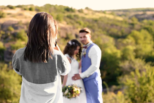 Wedding photographer taking photo of bride and groom