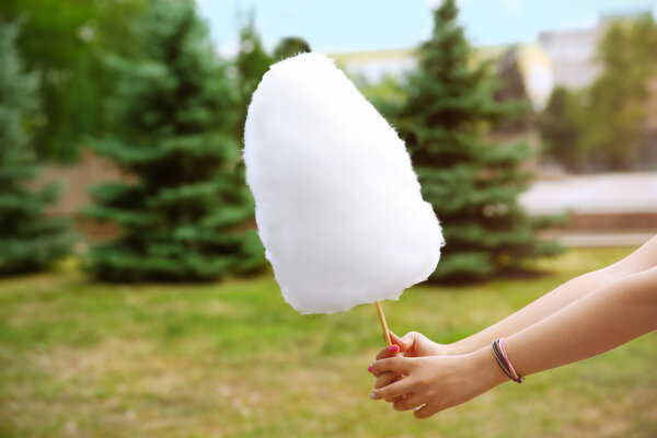 Женщина держит сахарную вату на улице
