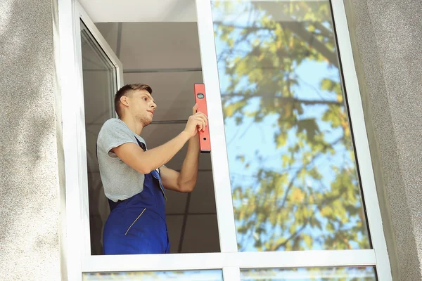 Byggande arbetare installera fönster — Stockfoto