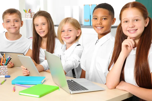 坐在教室里的小学生使用笔记本电脑和平板电脑 — 图库照片