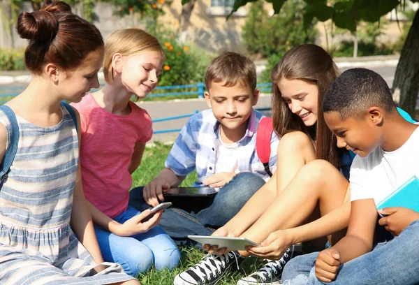 Studenti Con Telefoni Cellulari Tablet Seduti Sull Erba — Foto Stock