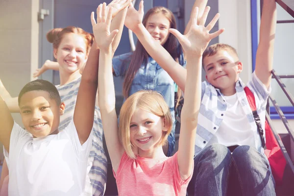 Fröhliche Schüler Mit Erhobenen Händen Auf Den Stufen Der Schule — Stockfoto