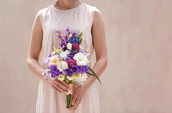 Vrouw met boeket van mooie bloemen op beige achtergrond — Stockfoto