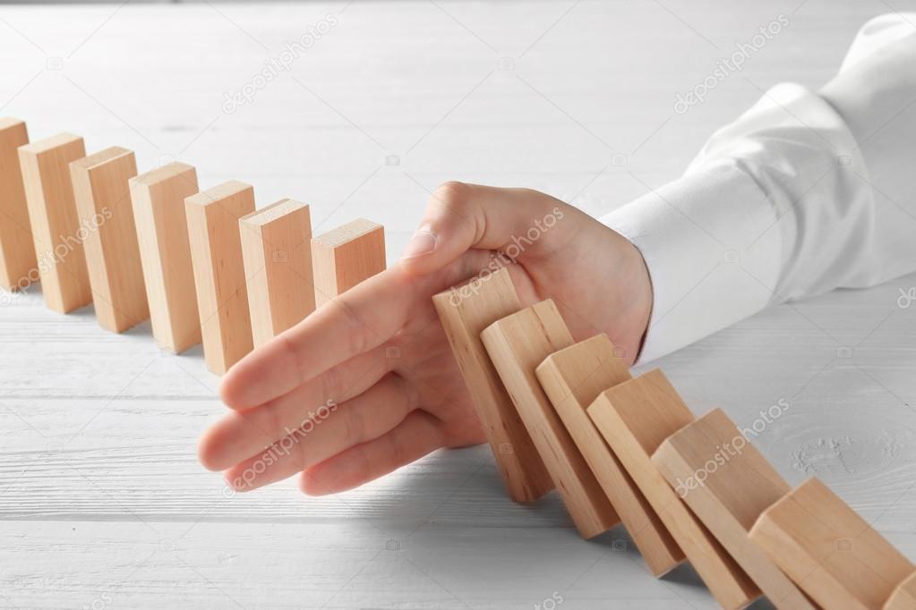 hand stopping domino effect
