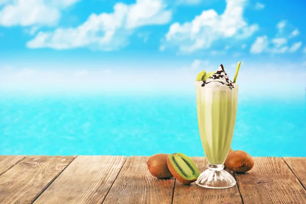 Delicious milkshake with kiwi on blue sky background — Stock Photo, Image