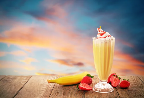 Delicioso batido con frutas sobre un hermoso fondo al atardecer — Foto de Stock