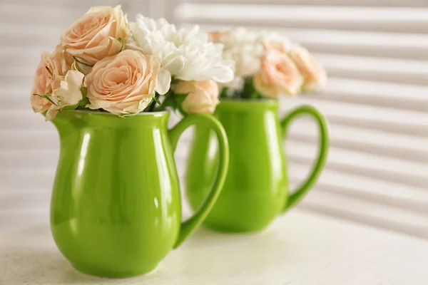 Bouquet of beautiful flowers in jugs on a  table — Stock fotografie