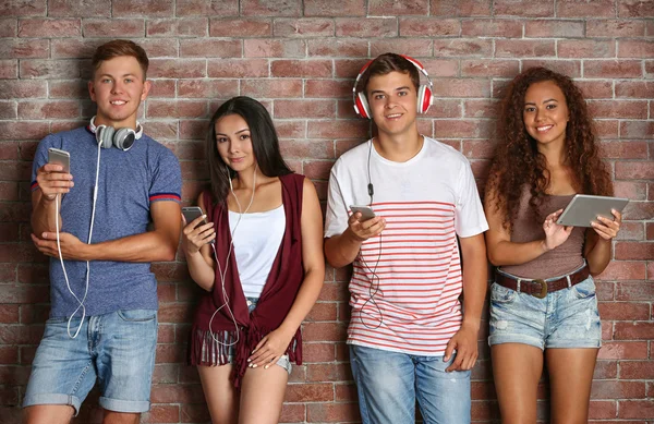 Glückliche Freunde Mit Gadgets Auf Backsteinmauer Hintergrund — Stockfoto