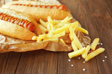 Lezzetli sosisli sandviç ve patates kızartması ahşap arka plan üzerinde