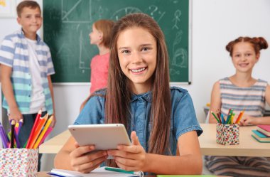 Sınıfta otururken tablet bilgisayar ile kız öğrenci