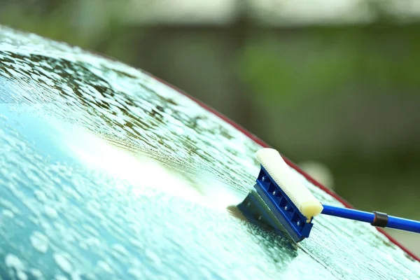 Washing windscreen with window cleaner — Stockfoto