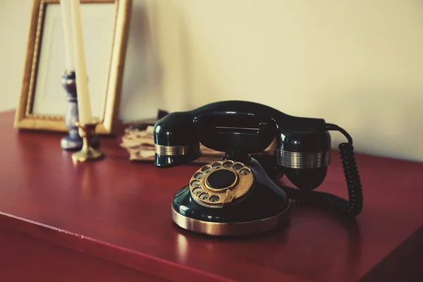 Old telephone on chest — Stockfoto