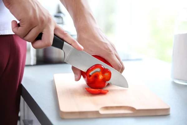 Jeune chef cuisinier couper le poivre — Photo
