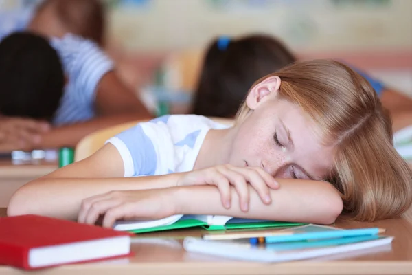 Tired schoolgirl in classroom — Stock Photo, Image