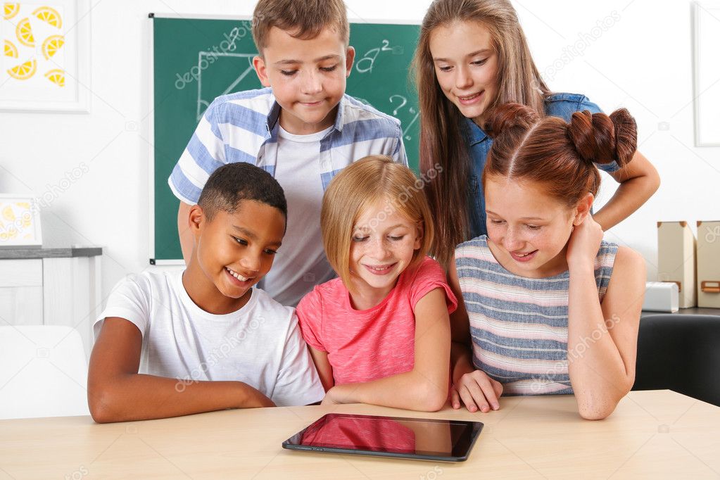 Schoolchildren with tablet computer in classroom