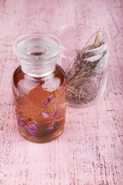 tentür ve otlar pembe ahşap zemin üzerinde cam şişe