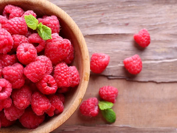 Ripe sweet raspberries in bowl on table close-up — Stock Photo, Image